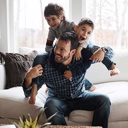 Parent and children playing on the couch.